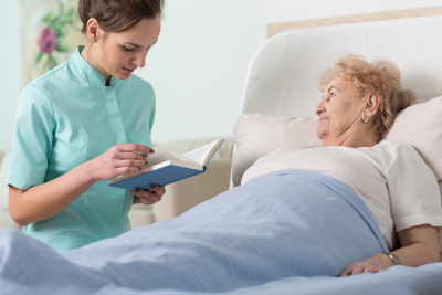 caregiver reading a book to a patient